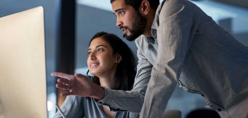 man and woman looking at computer
