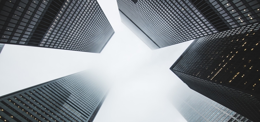 looking up at tall buildings and fog