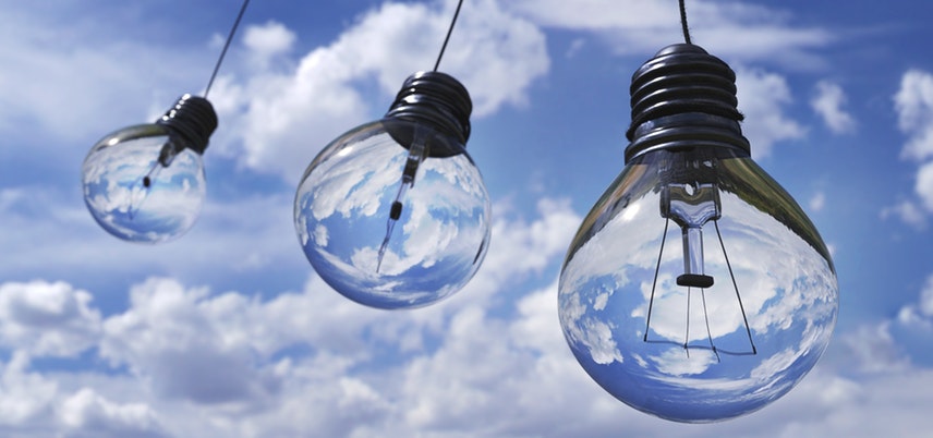 Photo of light bulbs with sky behind.