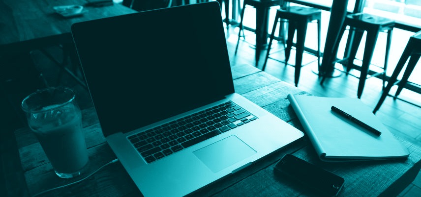 laptop and notebook on table at a cafe, blue tint