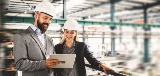 man and woman looking at tablet in a factory