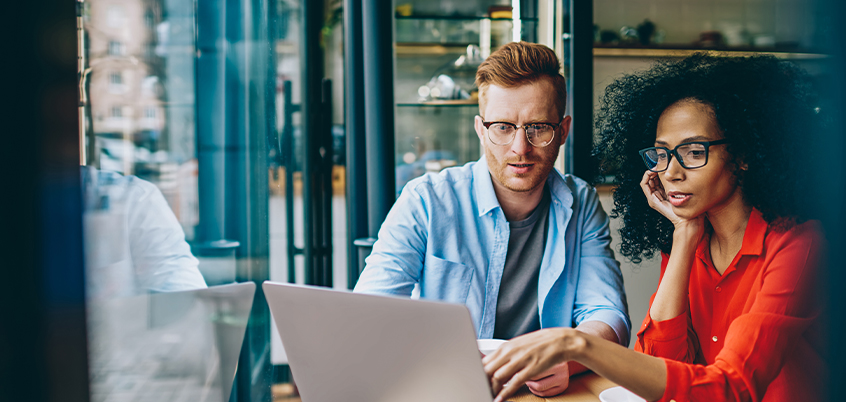 man and woman looking at laptop