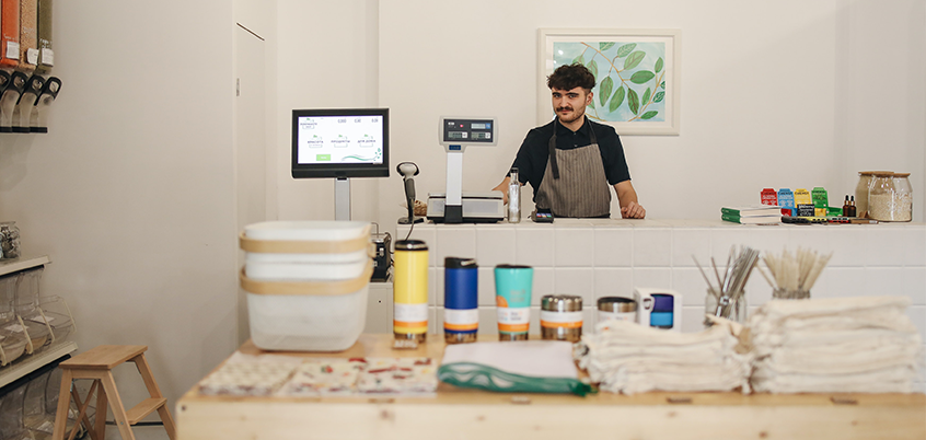 Shopkeeper standing at counter.