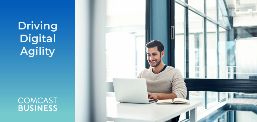 Driving Digital Agility headline with photo of man working on laptop at desk.