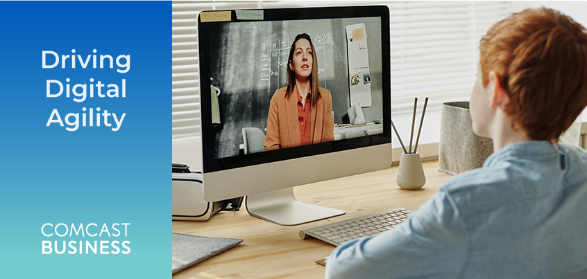 Child sitting at computer, teacher on computer screen