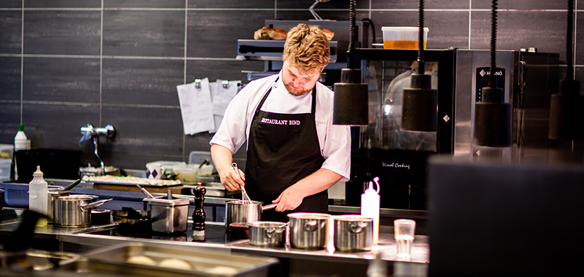 Chef whisking in kitchen.
