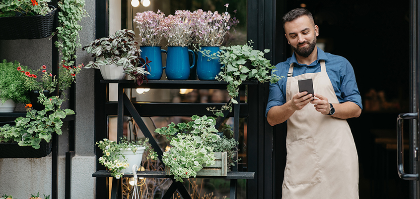 man smiling at phone at plant shop