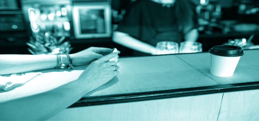 arms on a coffee shop counter, blue-green tint