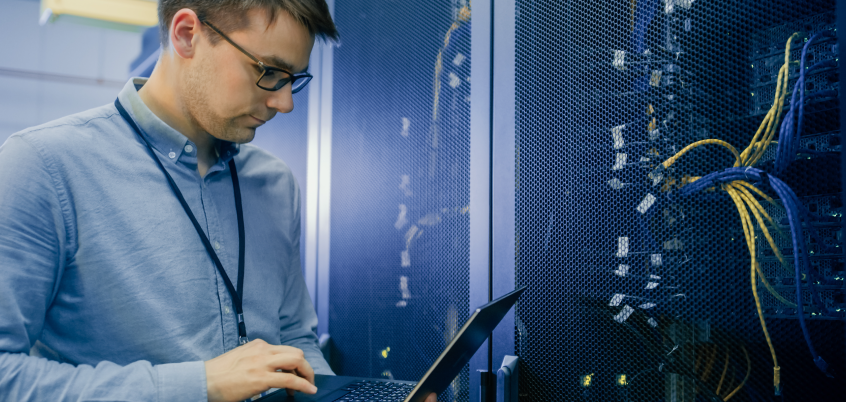 man standing in front of server with laptop