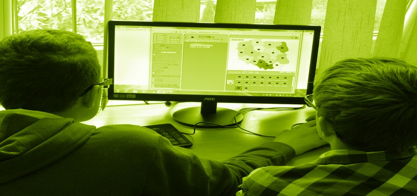 two children looking at a computer monitor, yellow-green tint over entire image