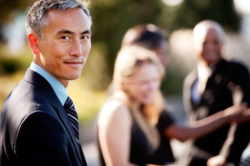man in suit, other people blurred in background