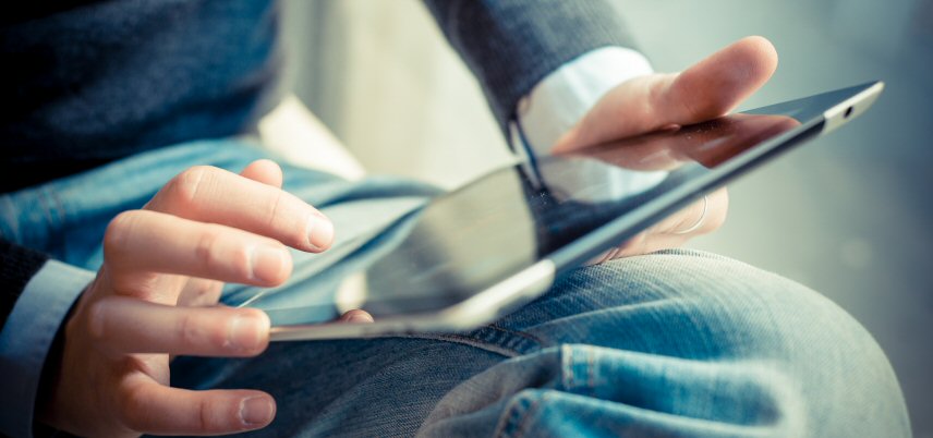 hands using a tablet in lap