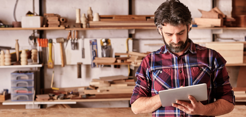 Man on tablet in workshop.