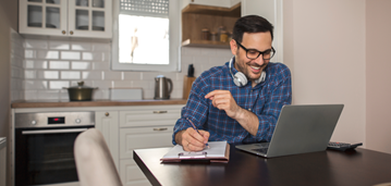 shutterstock_1718606404 Man On Lap Top Taking Notes