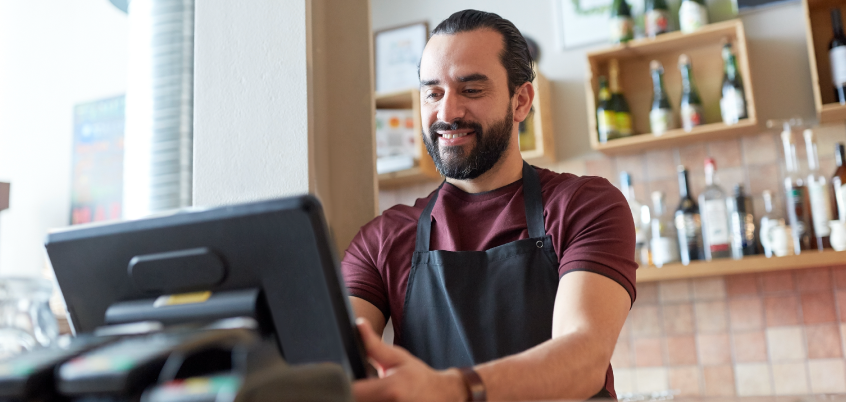 Man in apron at cash register
