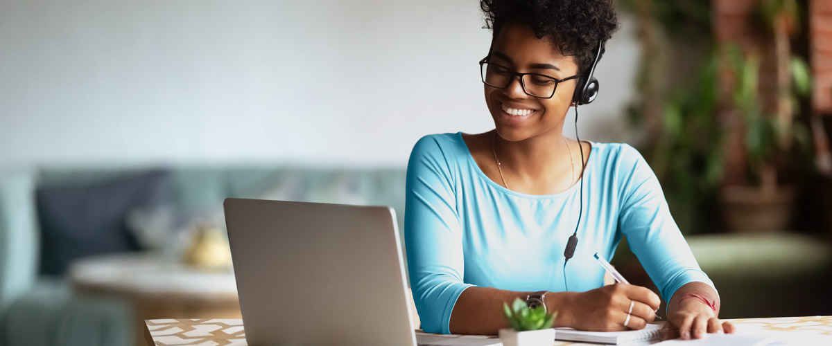 Woman with headphones working on laptop