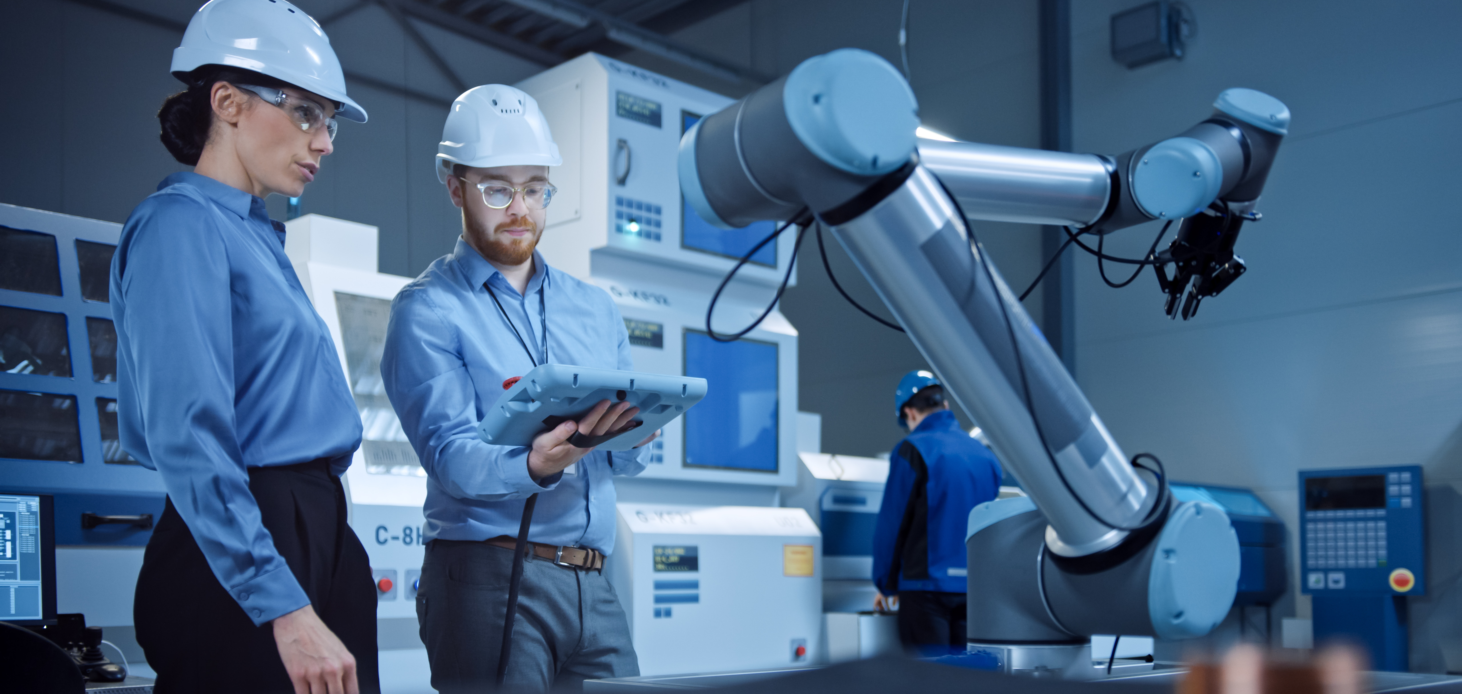 People in hard hats testing robotic arm