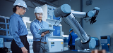 People in hard hats testing robotic arm