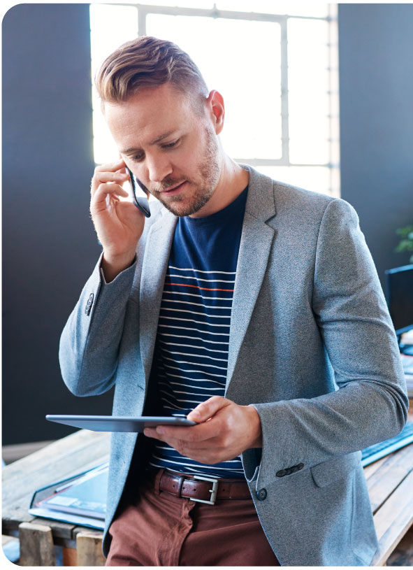 Man on smartphone looking at tablet