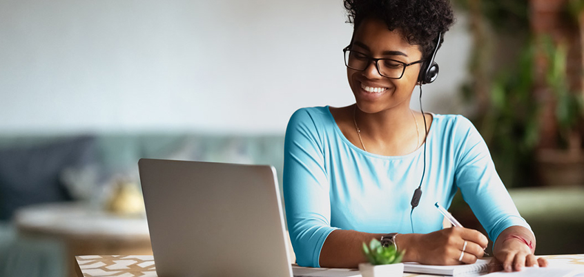 Woman with headphones working on laptop