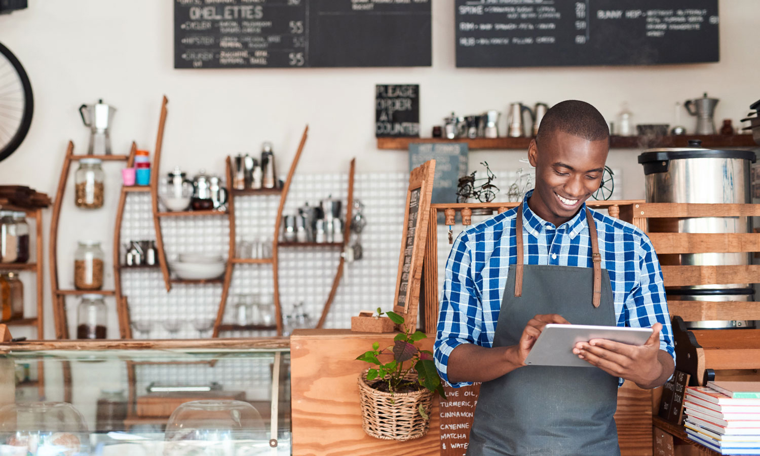 Man wearing work apron looking at mobile device