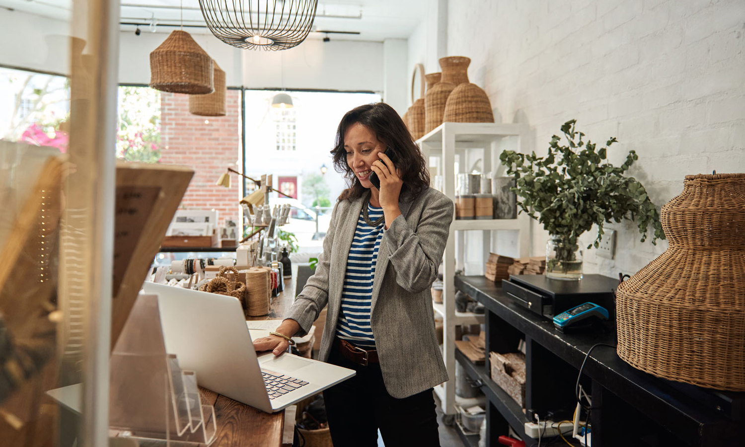 Woman on phone while looking at laptop
